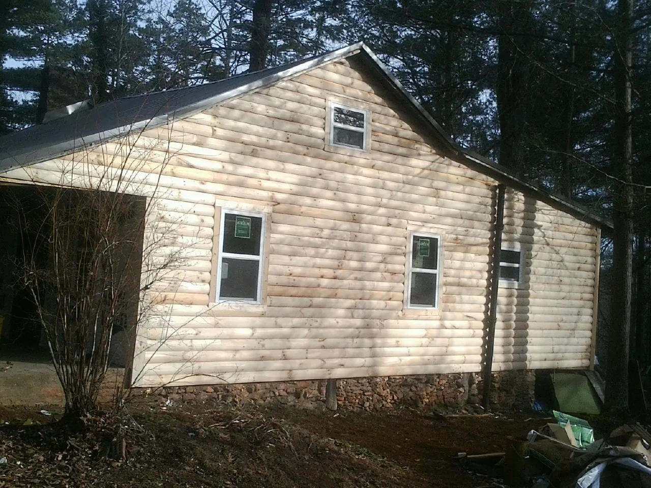 New log siding and dark metal roofing on a gable end in Beulaville