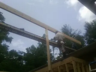 Carpenter setting a ridge beam over a new addition frame — Ice Dam Removal by Roofing Brothers in Beulaville