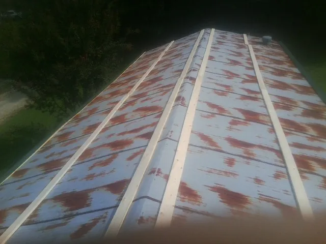 Rusted metal roof panels with new wood purlins before replacement — Storm Damage Roof Repair in Beulaville by Roofing Brothers