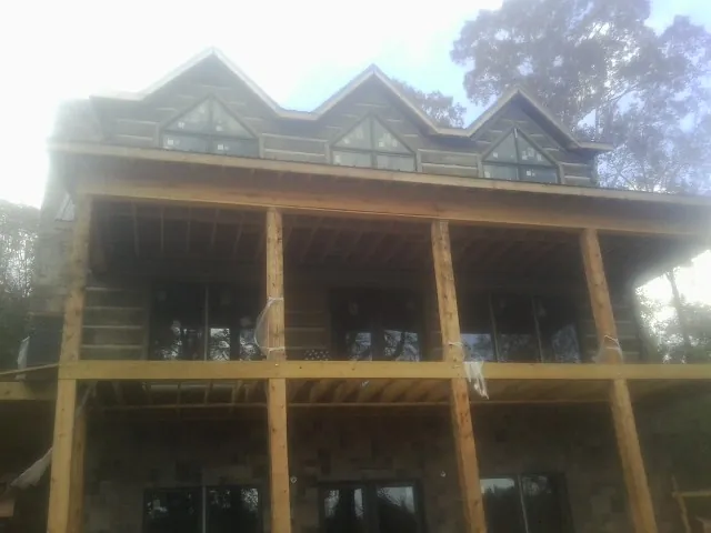 Dormers and porch framing on a large log home under construction — Roof Coating work by our crew in Beulaville