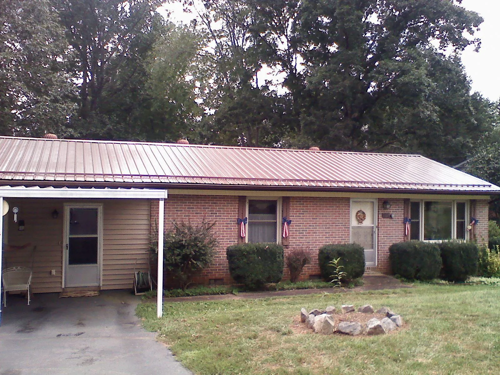 Bronze metal roof and carport on a brick ranch home — Roof Repair work by our crew in Beulaville